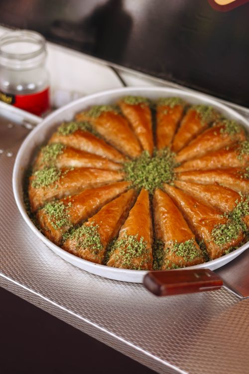 Free Tray of freshly baked traditional baklava topped with crushed pistachios, perfect for dessert lovers. Stock Photo