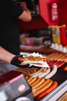 Delicious hot dogs being served at a street food stall with a variety of sausages.