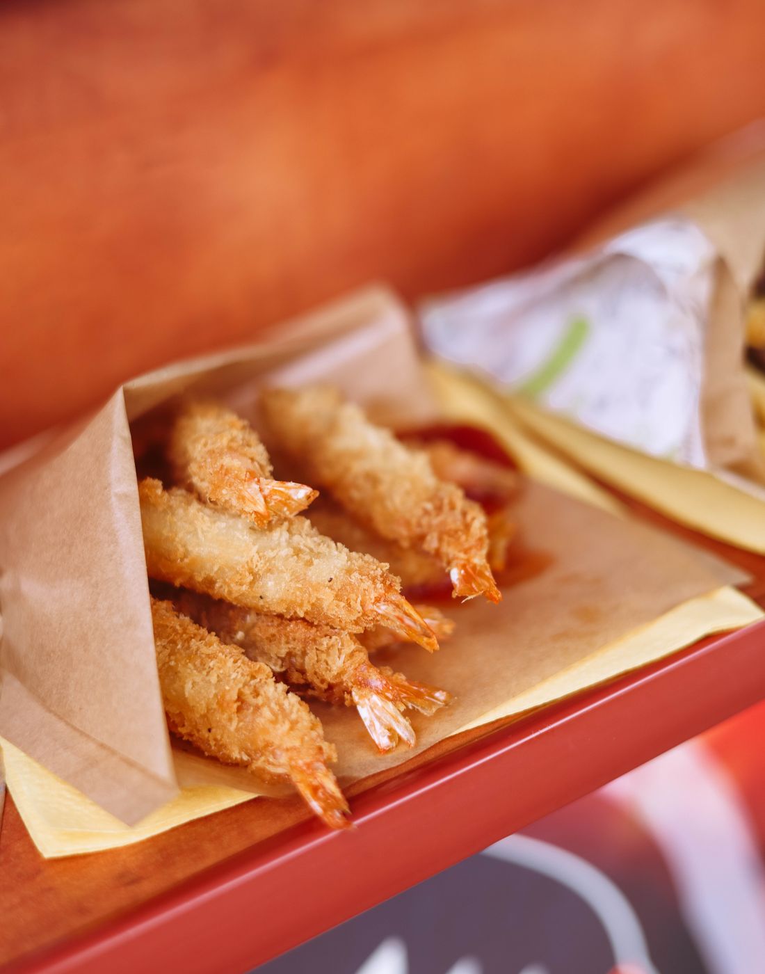 Golden fried shrimp in a paper cone, perfect for a delicious snack or meal.