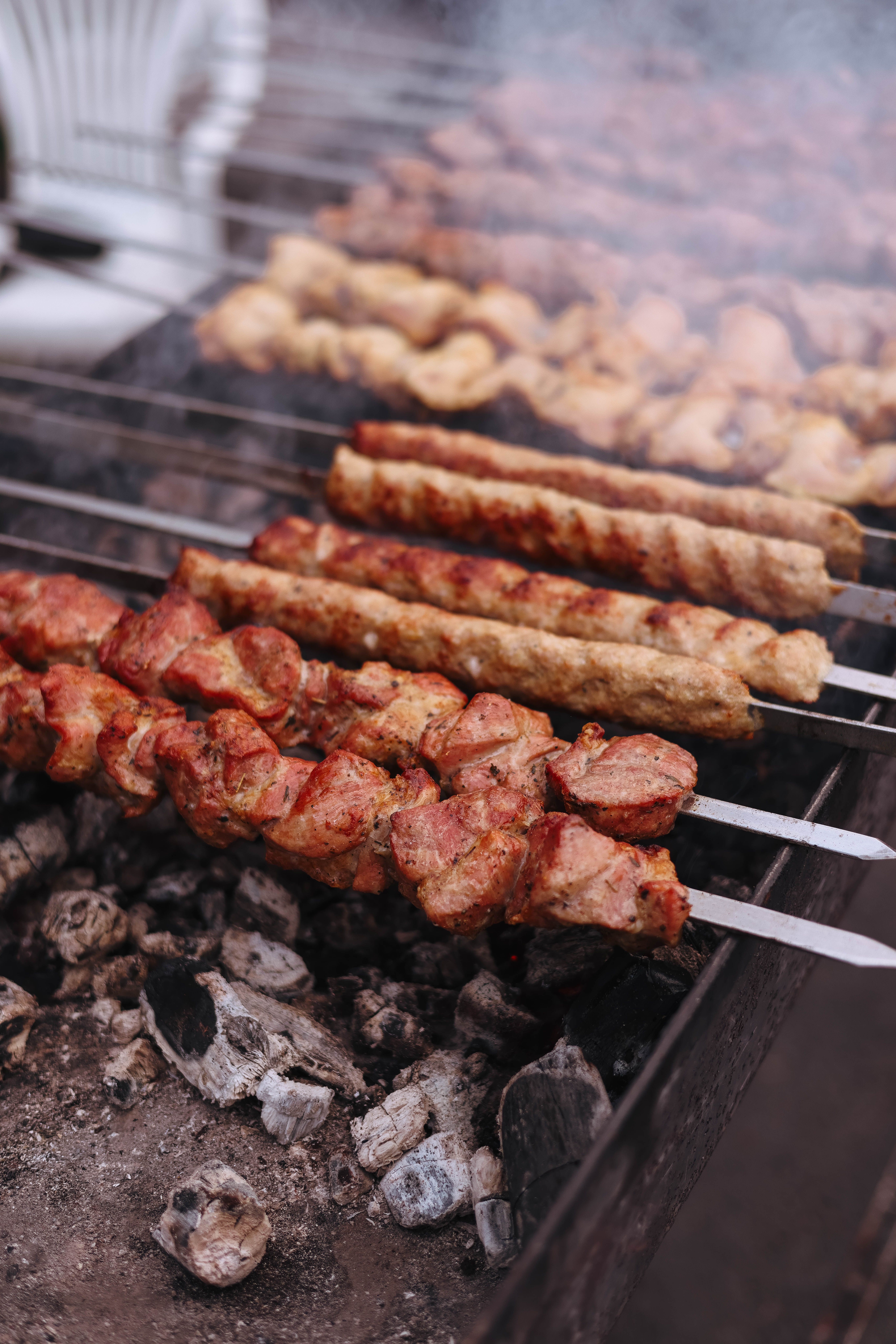 Deliciously grilled meat skewers sizzling over hot charcoal, perfect for a summer barbecue.