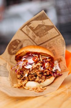 Appetizing pulled pork sandwich with coleslaw served on rustic paper, perfect for a casual lunch.