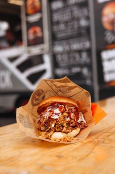 Savory BBQ pulled pork sandwich with coleslaw at a food truck, perfect for a flavorful lunch.