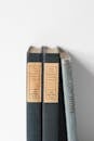 Three books on a shelf with a white background