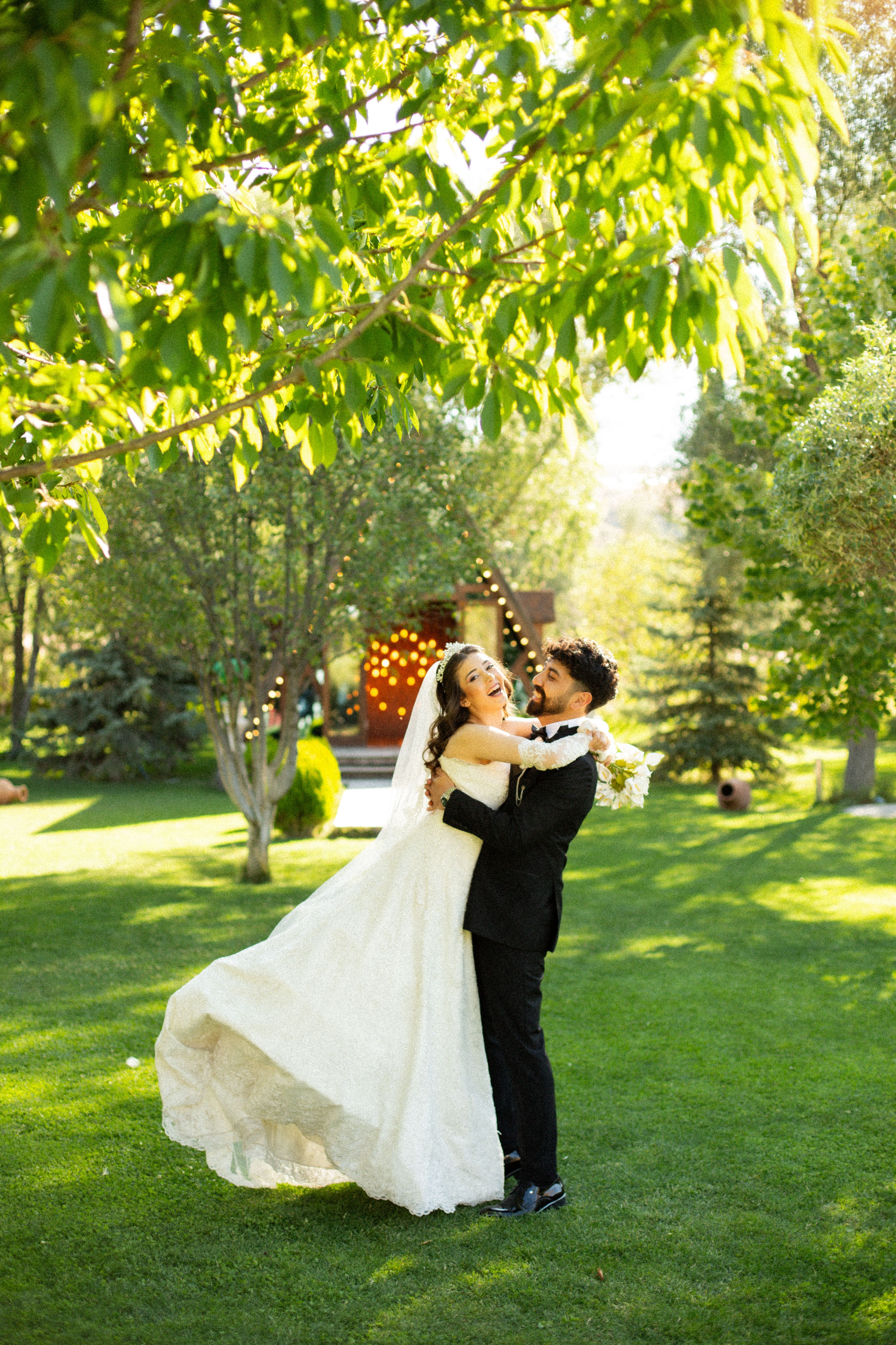 A bride and groom are hugging in the grass · Free Stock Photo
