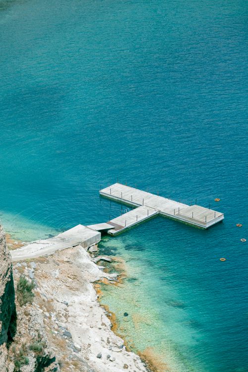 Free A serene pier extending into clear turquoise waters, perfect for a relaxing getaway. Stock Photo