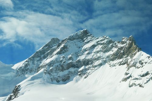 Free Stunning view of a snow-covered mountain peak under a clear blue sky, showcasing the beauty of winter landscapes. Stock Photo