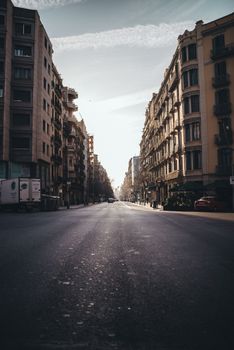 A peaceful city street view with sunlight casting long shadows in an urban environment.
