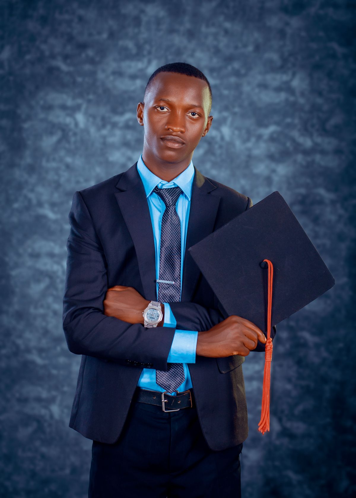 A proud young graduate holding his graduation cap