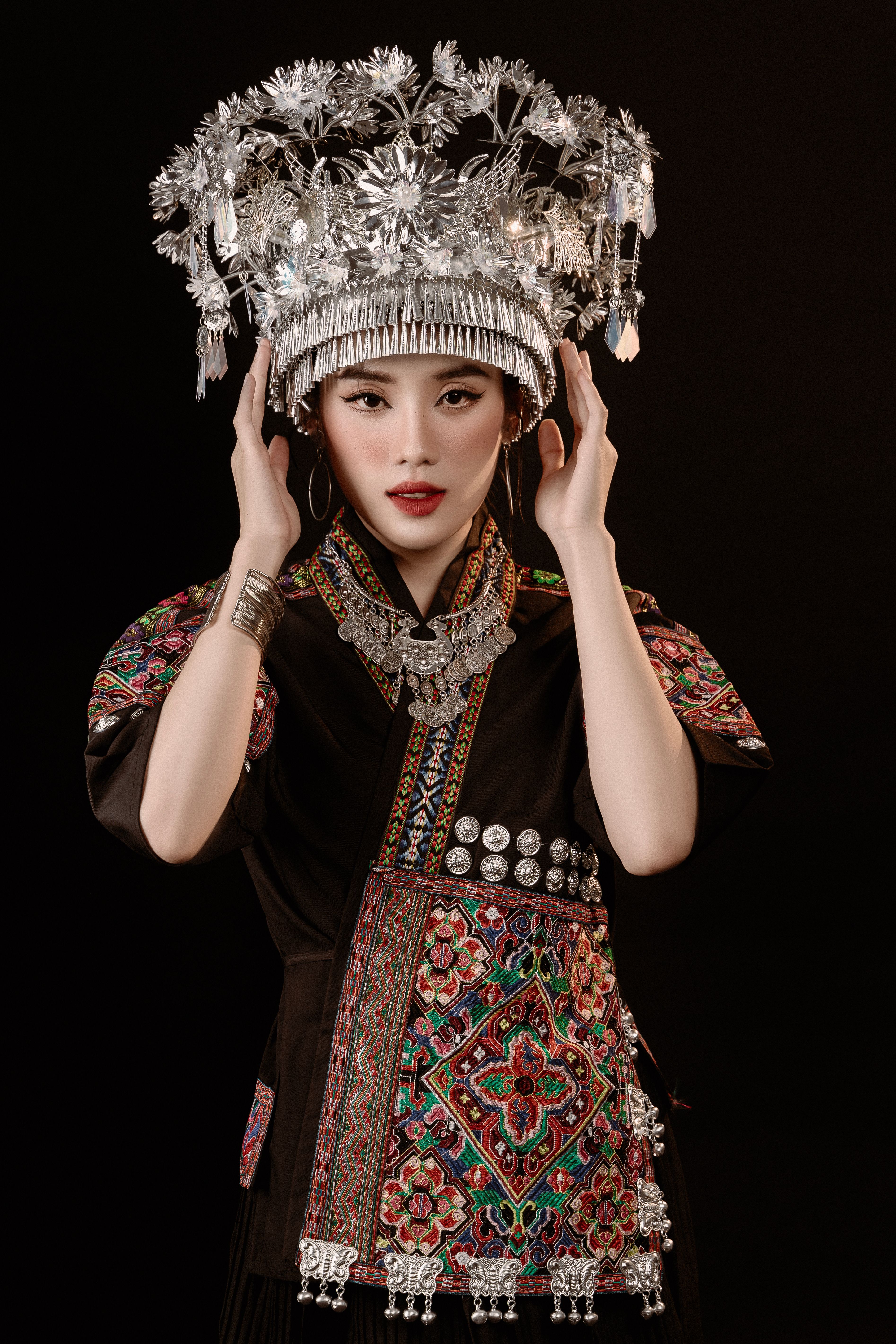 Portrait of a young woman in traditional Vietnamese ethnic attire with ornate headdress.