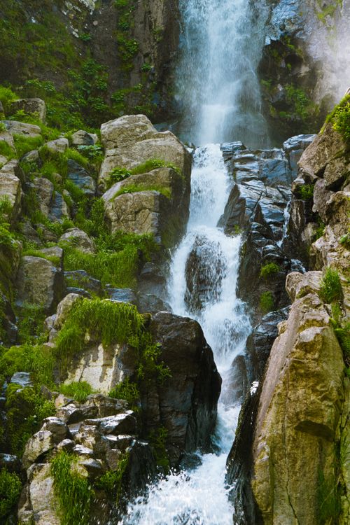 Free Scenic waterfall cascading over moss-covered rocks in a serene woodland setting. Stock Photo