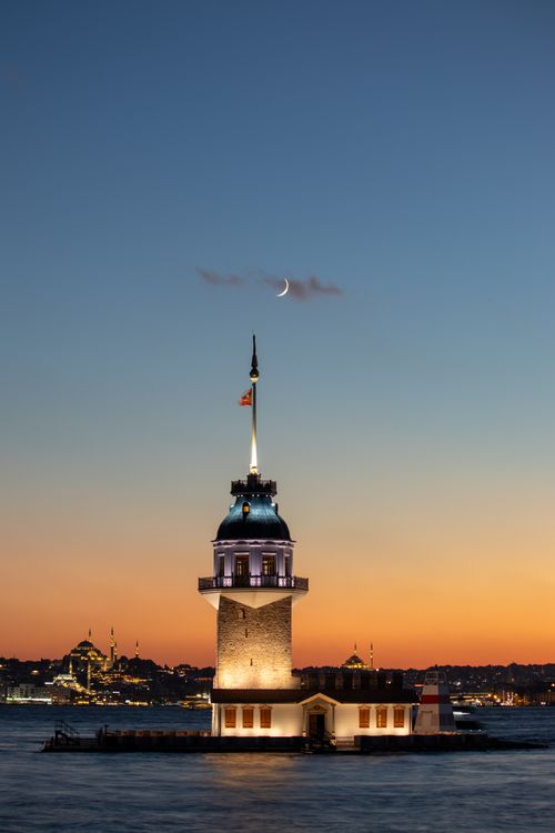 Free Beautiful sunset view of Maiden's Tower in Istanbul with a crescent moon above. Stock Photo