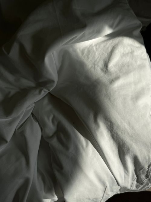 White bedding lit by morning sun — Tetiana Androshchuk on Pexels