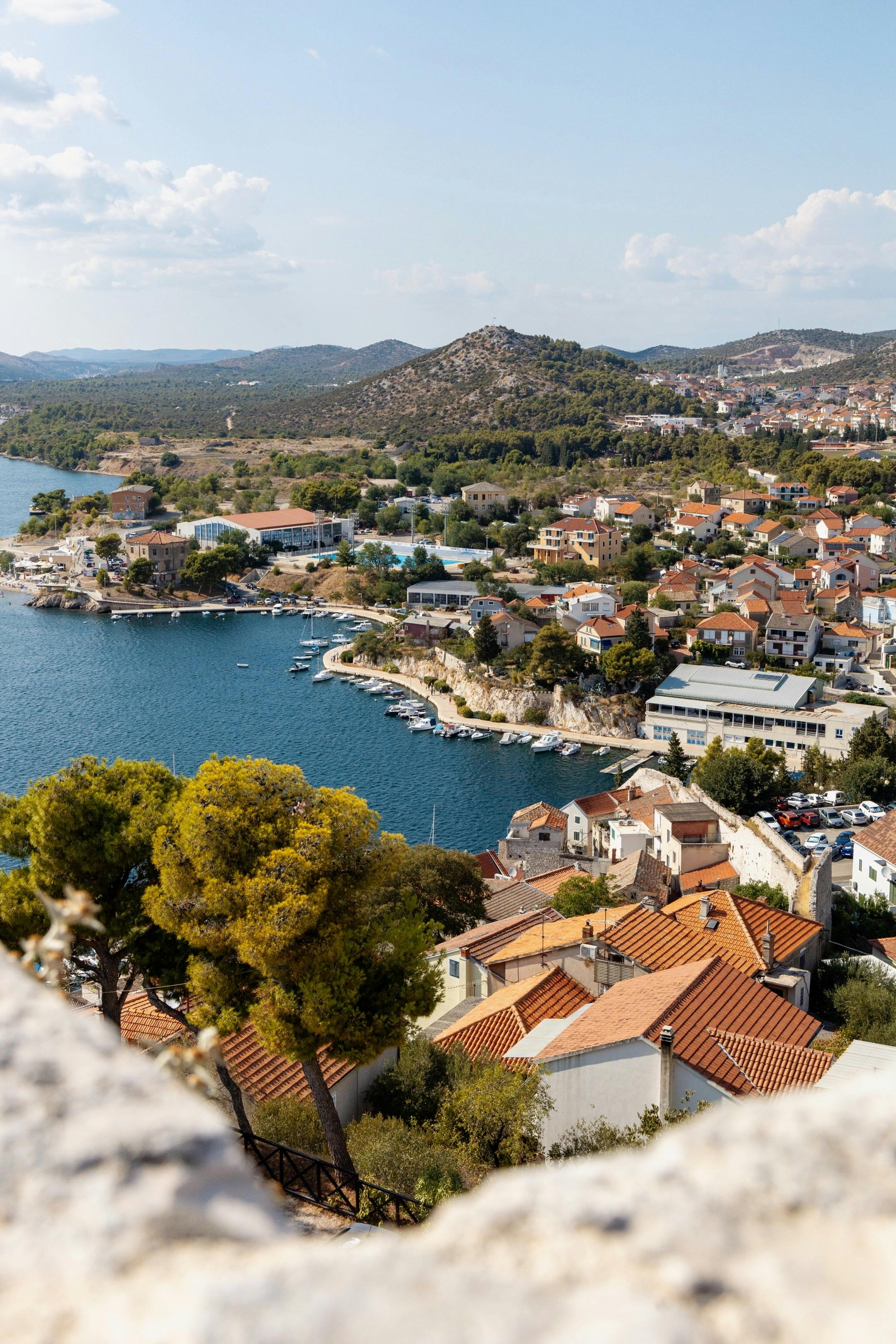 Beautiful view of a Mediterranean coastal town with terracotta rooftops and clear blue waters.
