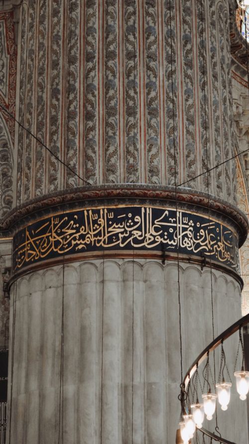 Free Intricate Islamic calligraphy adorns a mosque column, showcasing traditional architectural artistry. Stock Photo