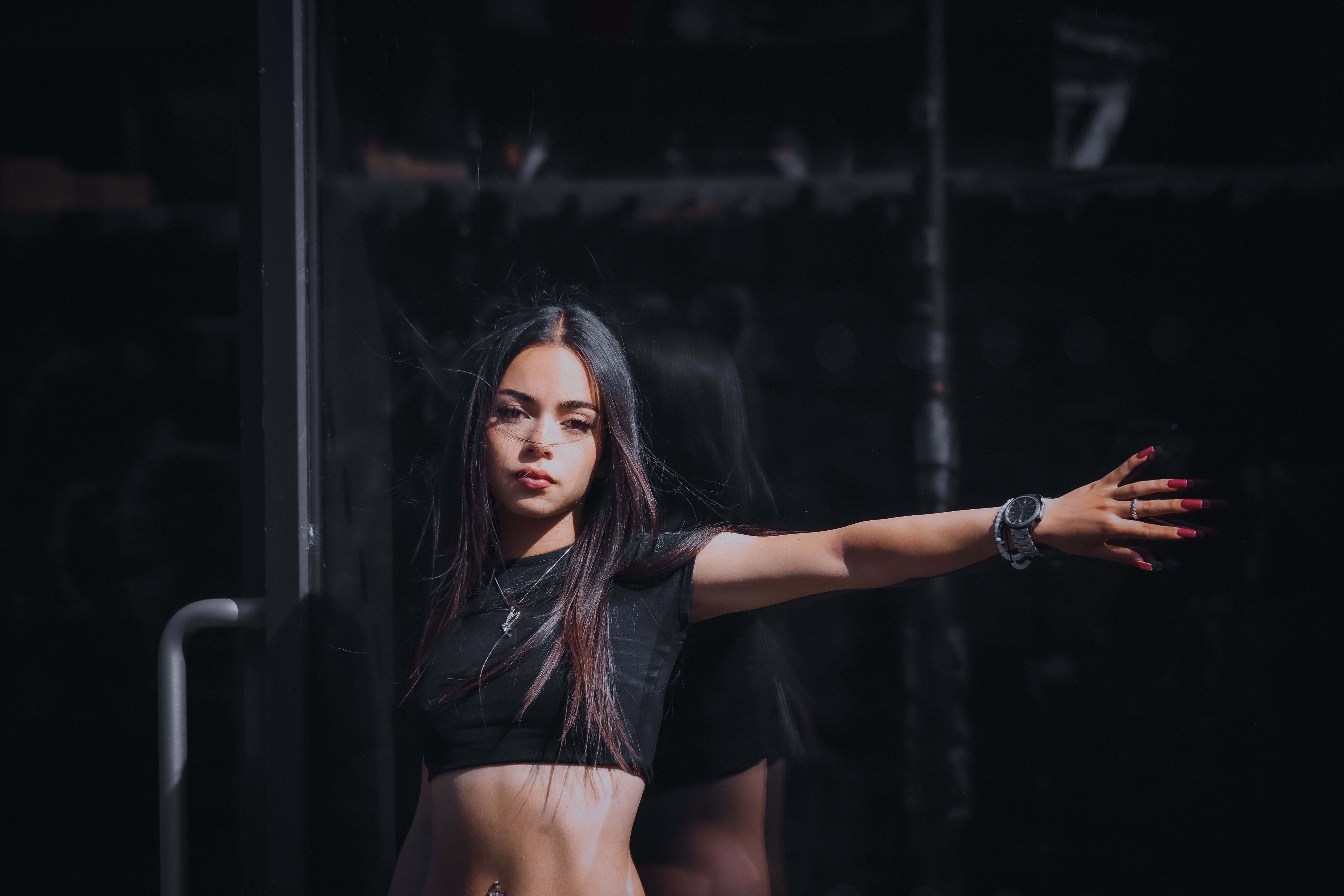 A woman in a black top and black pants is posing · Free Stock Photo