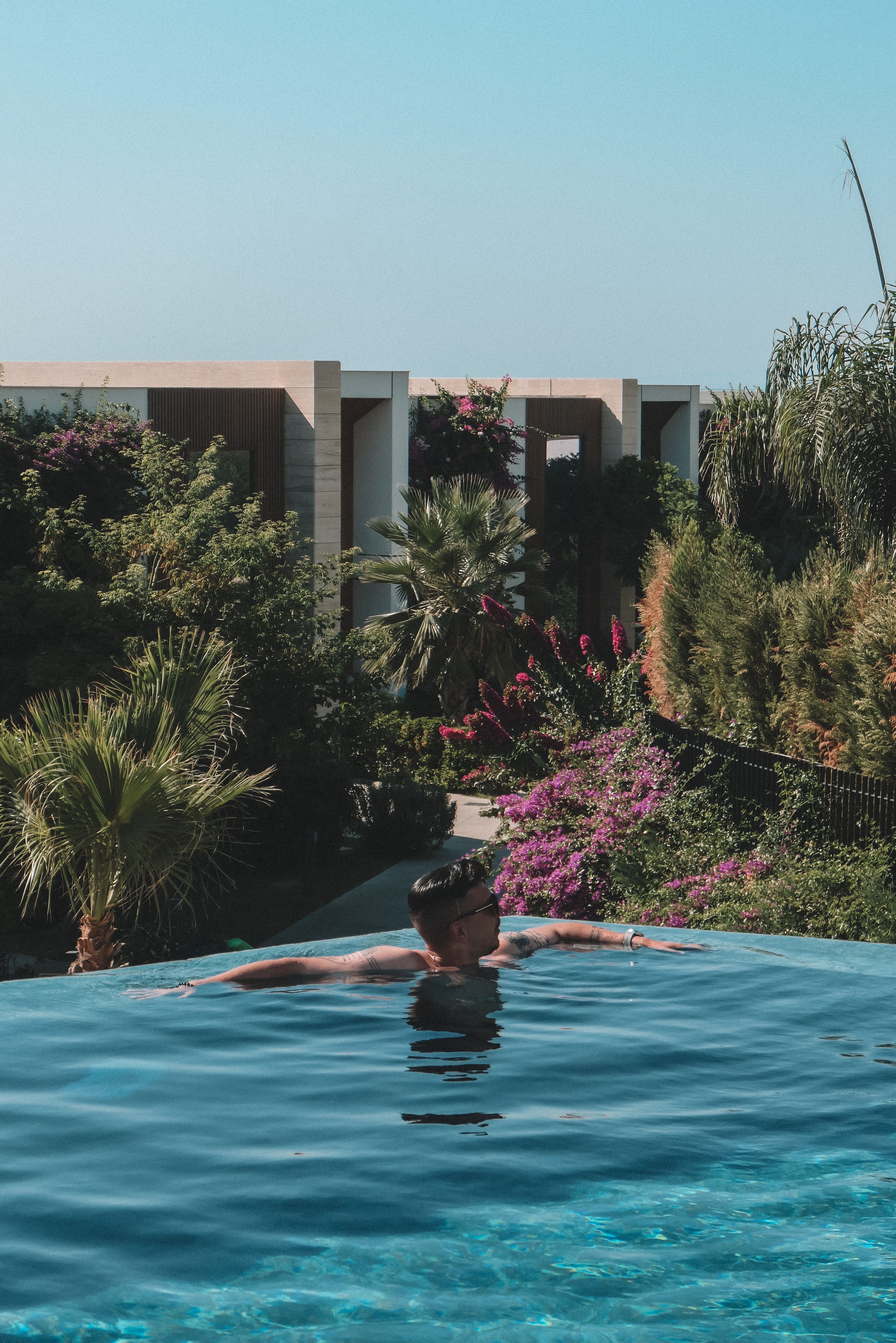 A man in a pool with a view of the ocean · Free Stock Photo