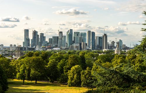 Free Panoramic view of London's Canary Wharf skyline from lush Greenwich Park. Stock Photo
