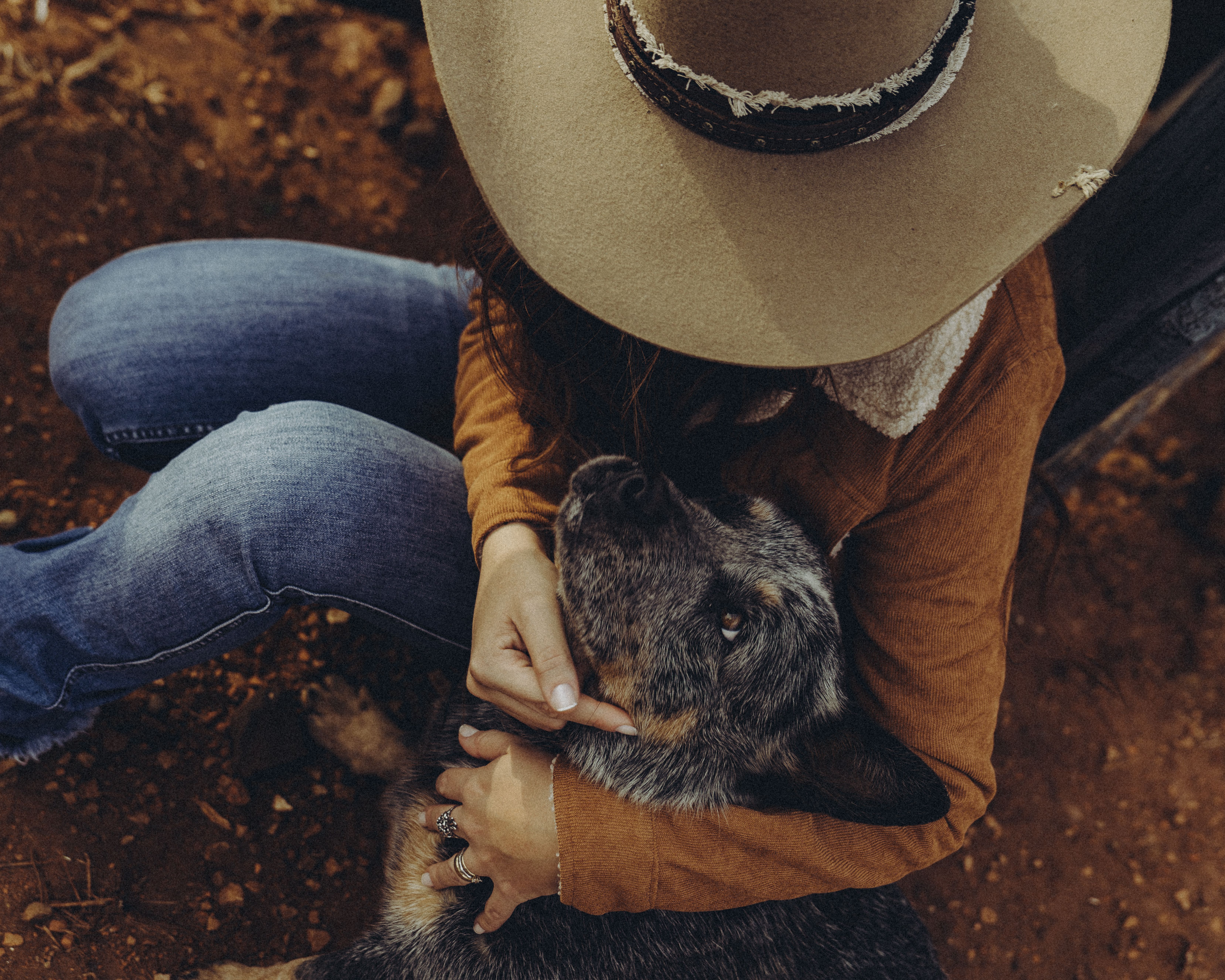 A cowgirl gently embraces her dog outdoors in Arapongas, Brazil. Capture of rural life.