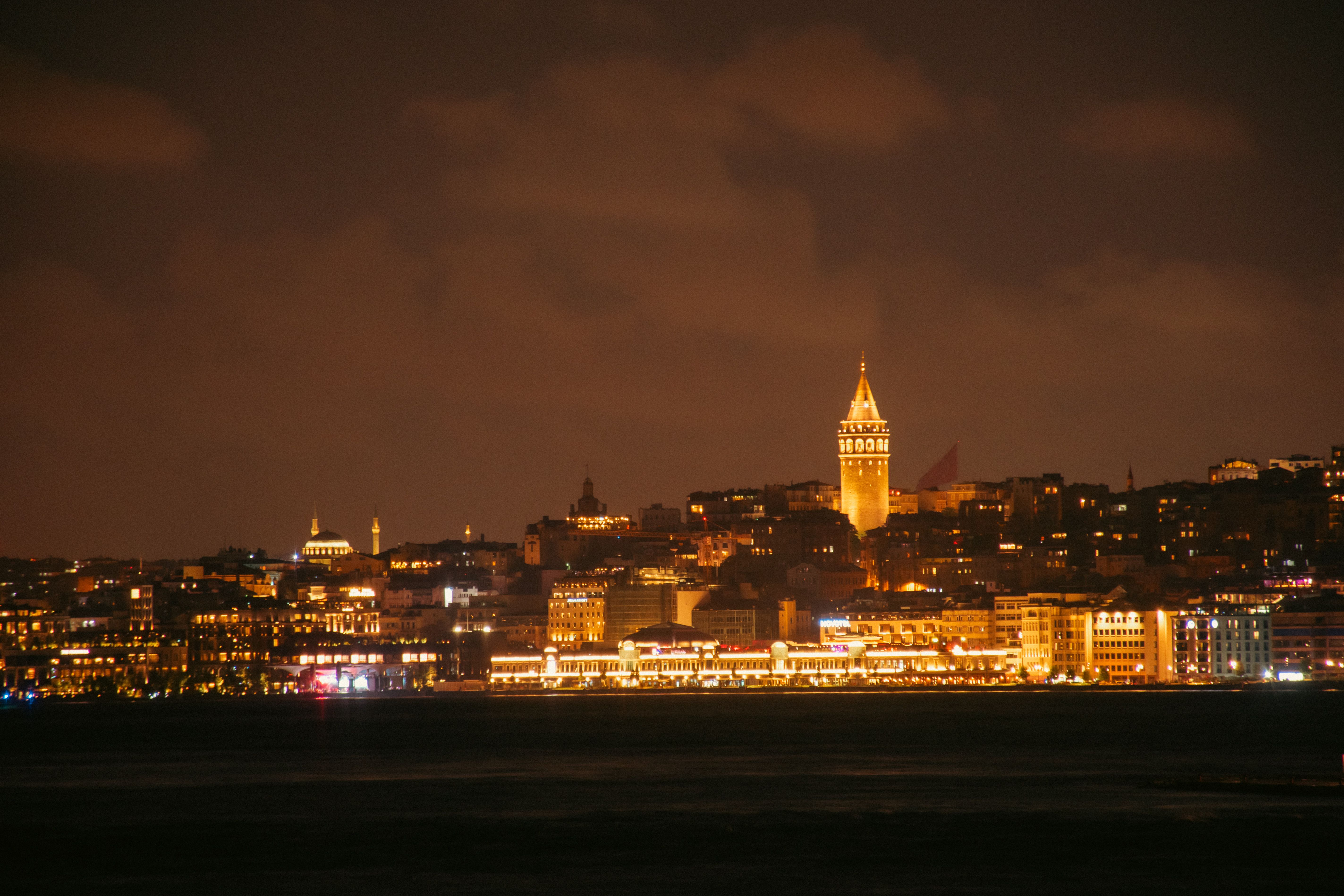 Stunning night skyline of Istanbul featuring the historic Galata Tower illuminated over the Bosphorus.
