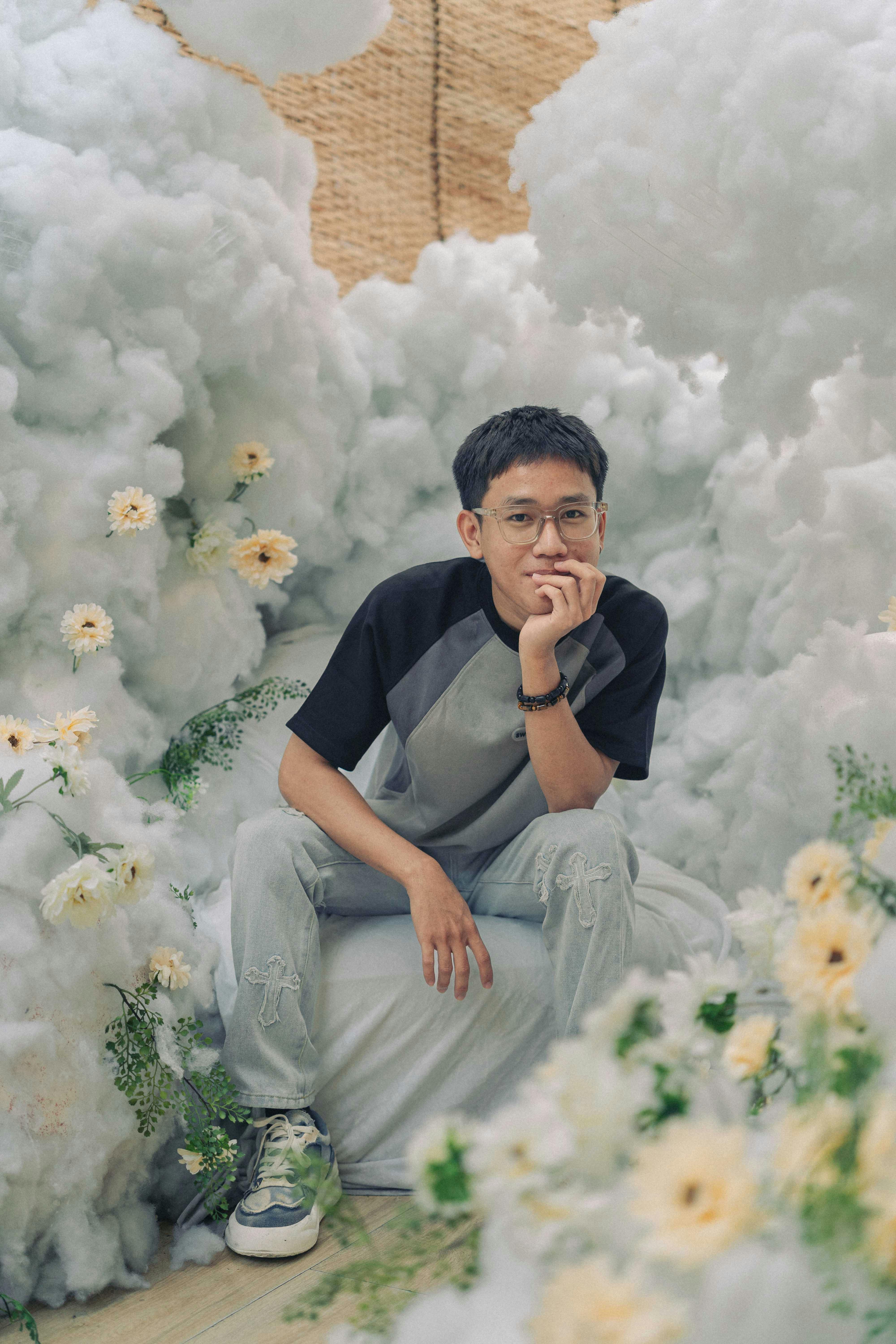 a man sitting on a cloud with flowers