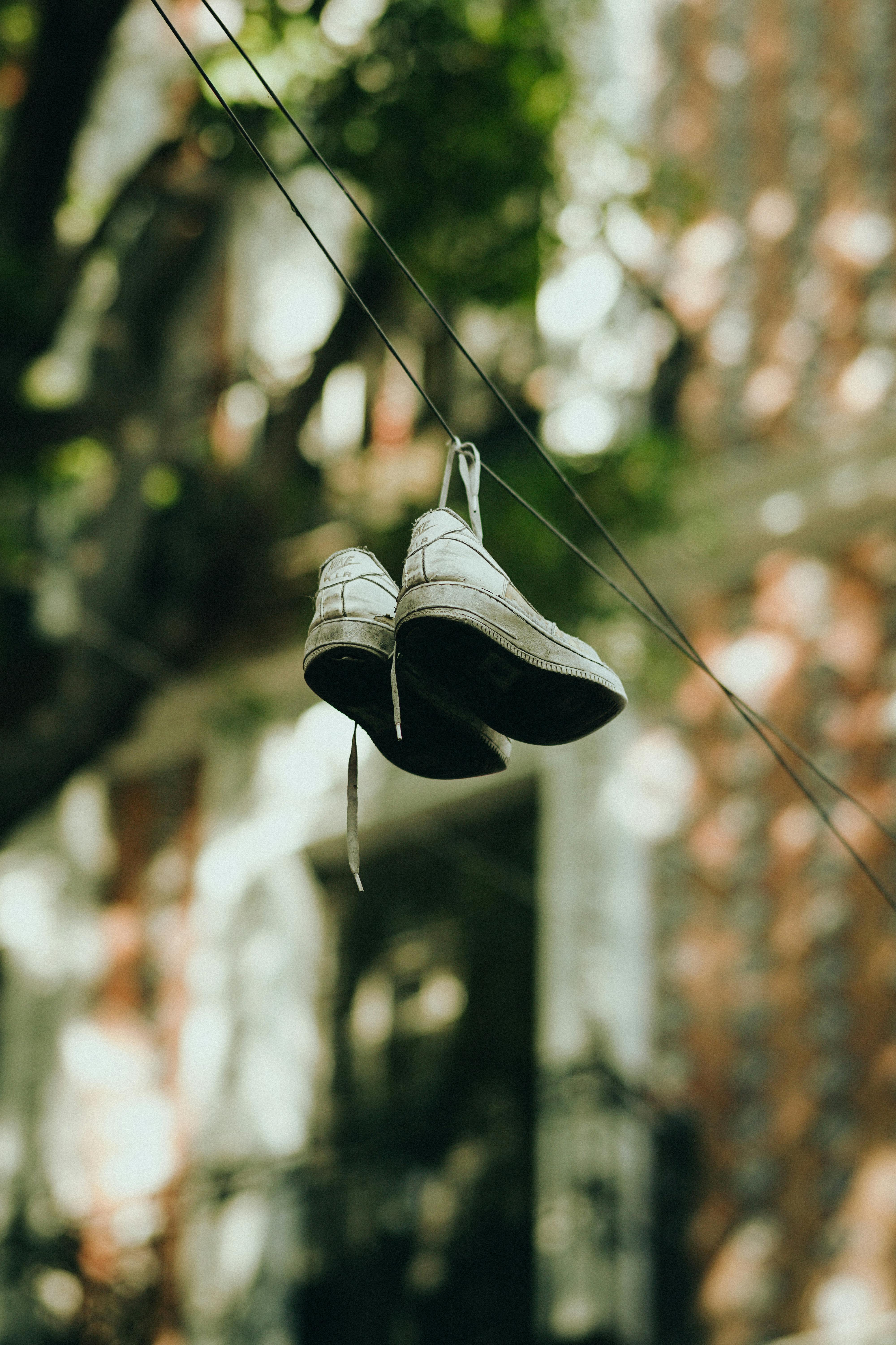 Old sneakers hanging on a wire, symbolizing urban culture and mystery.
