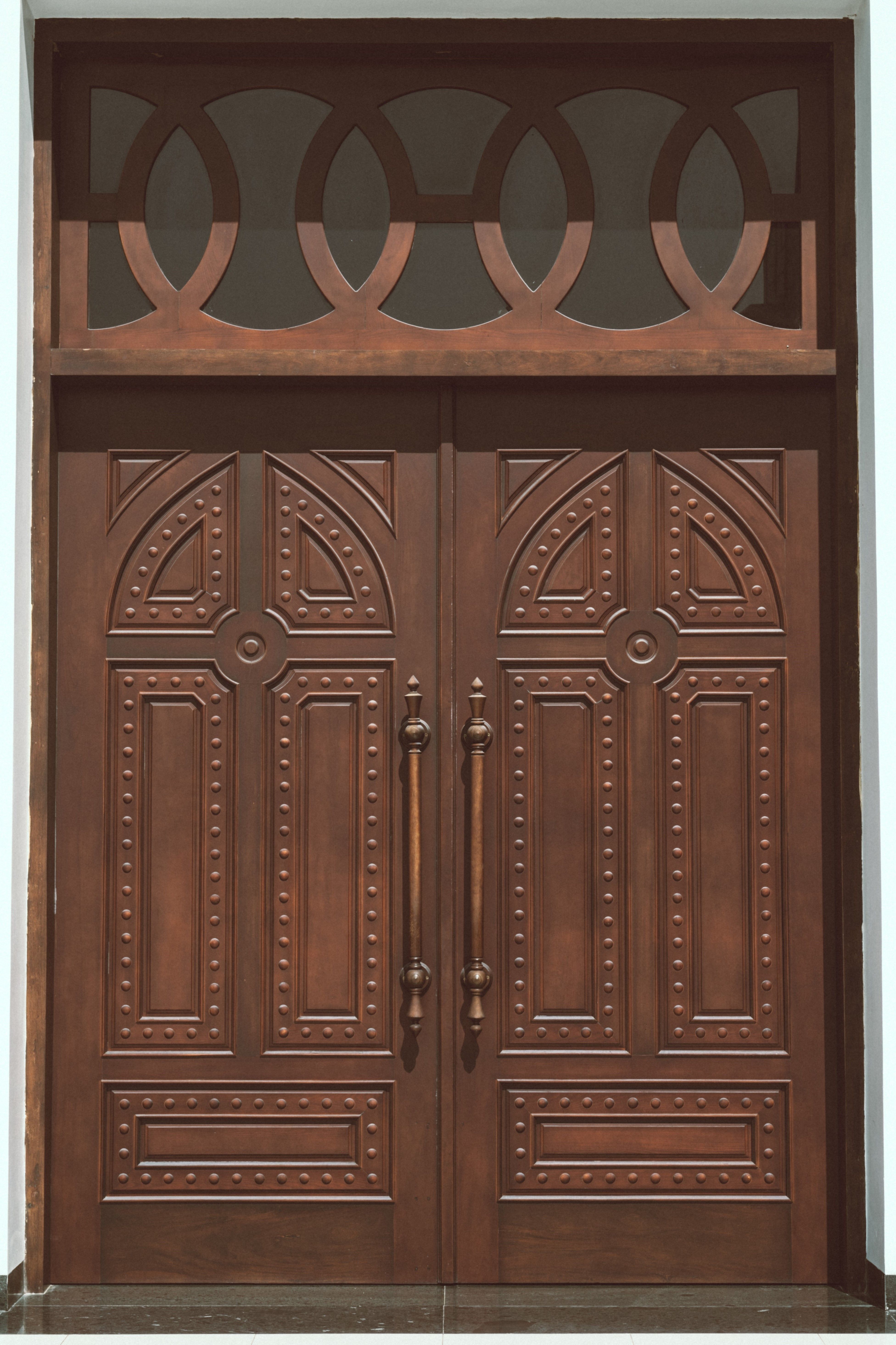 Classic ornate wooden double door with decorative design, suitable for homes and businesses.