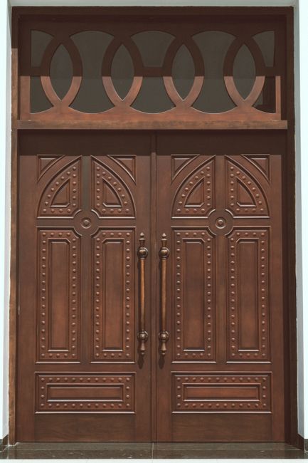 Classic ornate wooden double door with decorative design, suitable for homes and businesses.