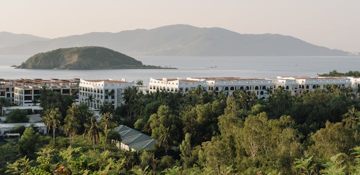 A serene view of a coastal resort surrounded by lush greenery and ocean.