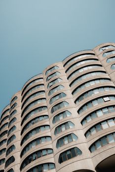 Explore the unique curves and lines of this modern brutalist skyscraper in an urban setting.