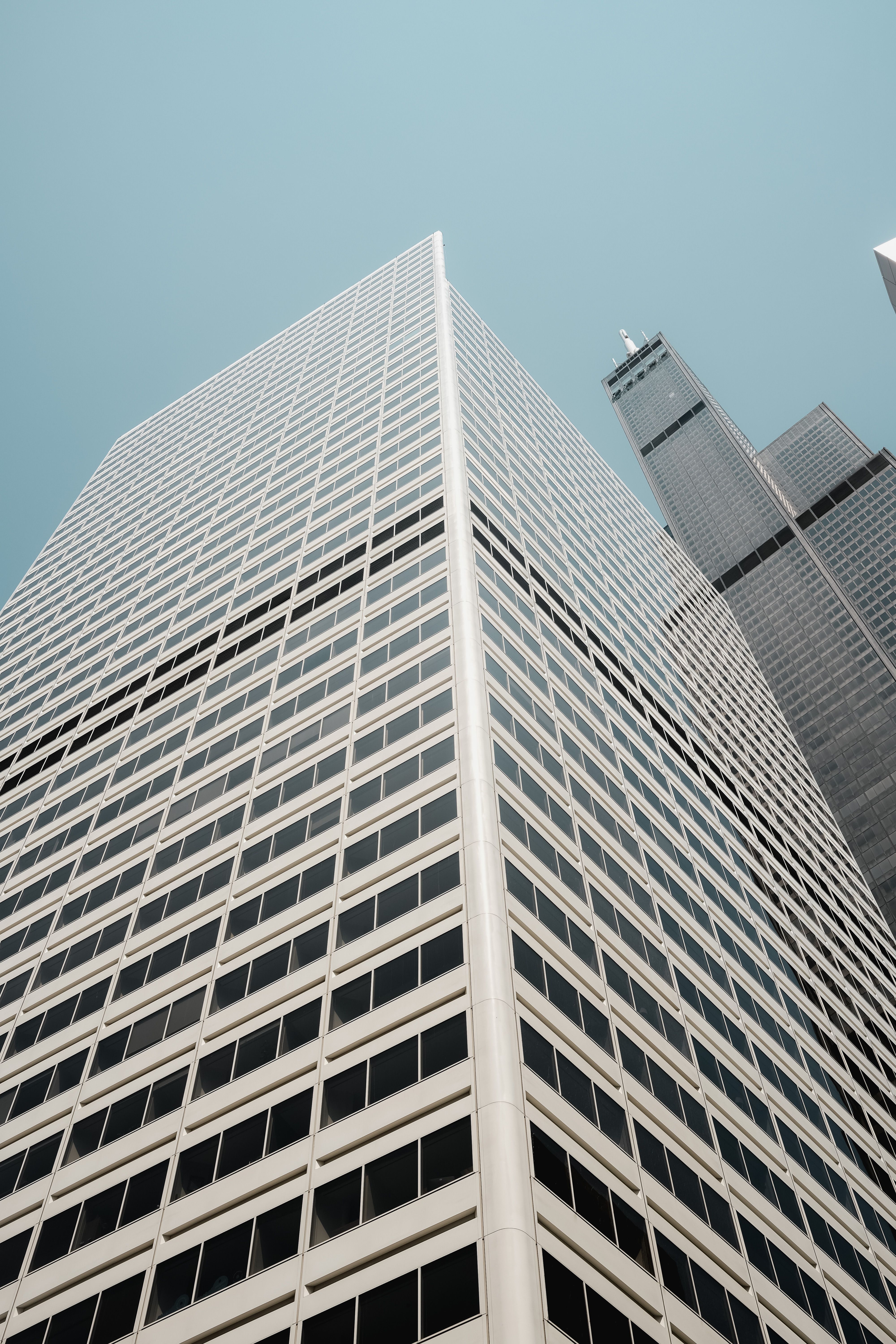 A tall building with a blue sky in the background · Free Stock Photo