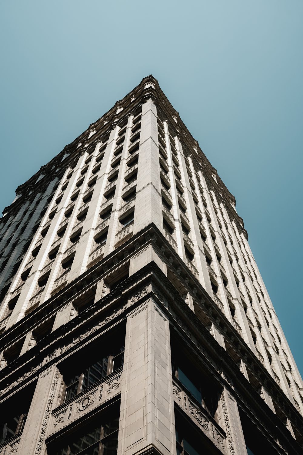 A tall building with a blue sky in the background · Free Stock Photo