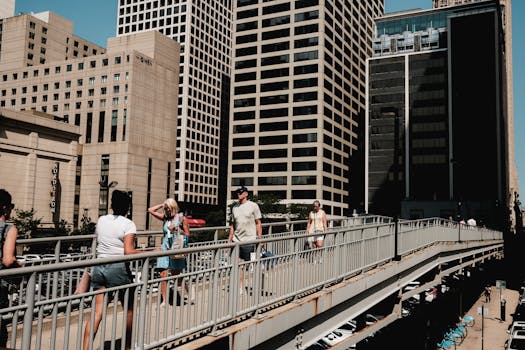 People walking on a bridge in the vibrant downtown Chicago with modern skyscrapers.