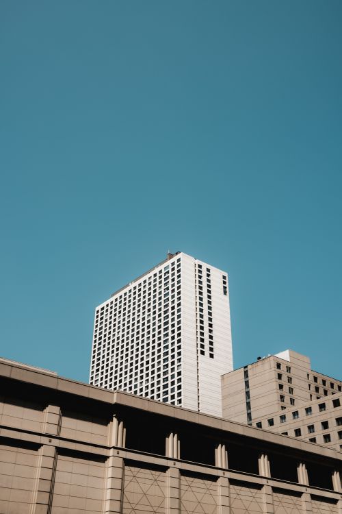 Free City skyscrapers rise tall against a clear blue sky, showcasing urban architectural design. Stock Photo