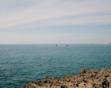 Serene view of the sea with distant boats near Phan Rang, Vietnam, under a clear sky.