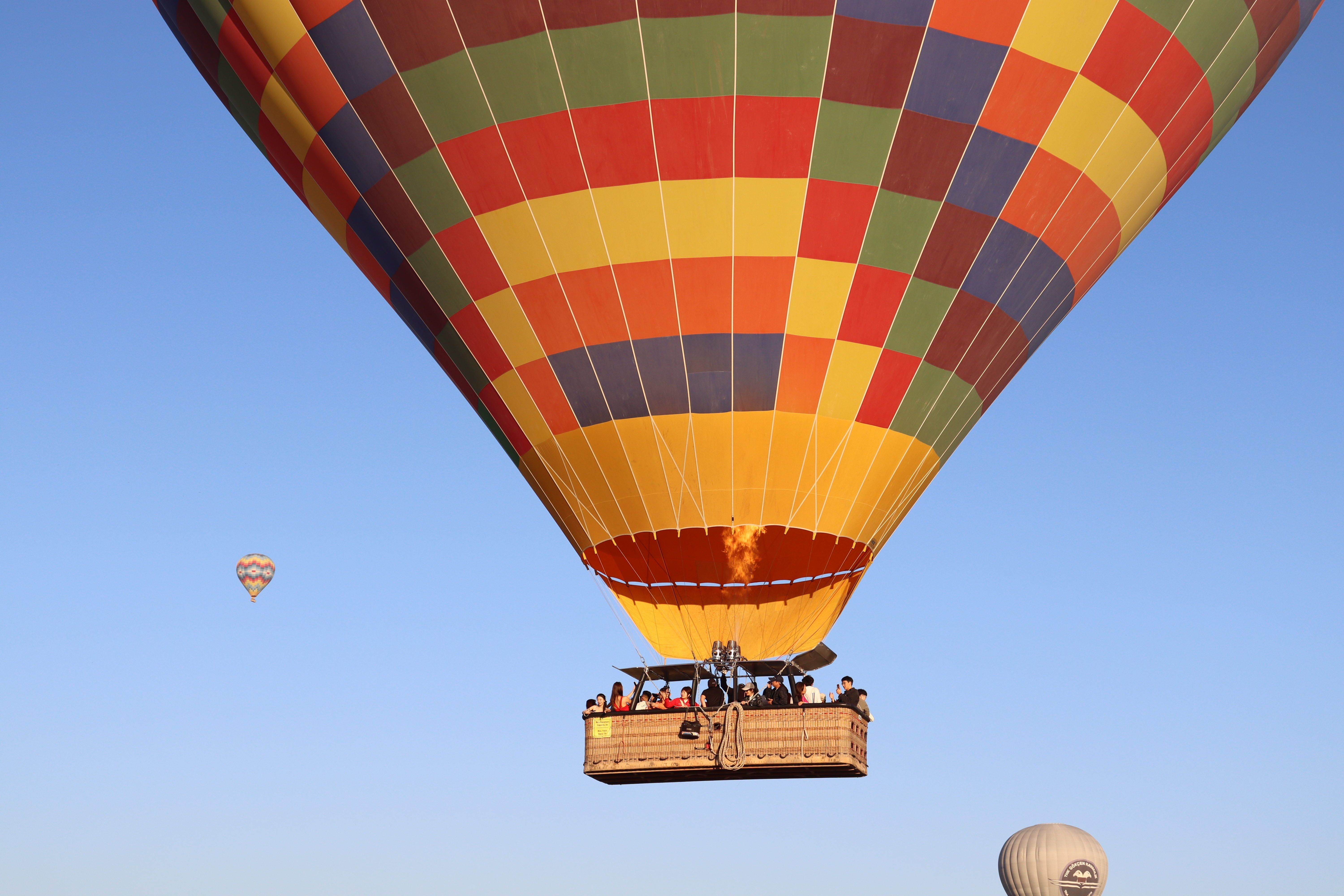 A hot air balloon flying in the sky with a blue sky · Free Stock Photo