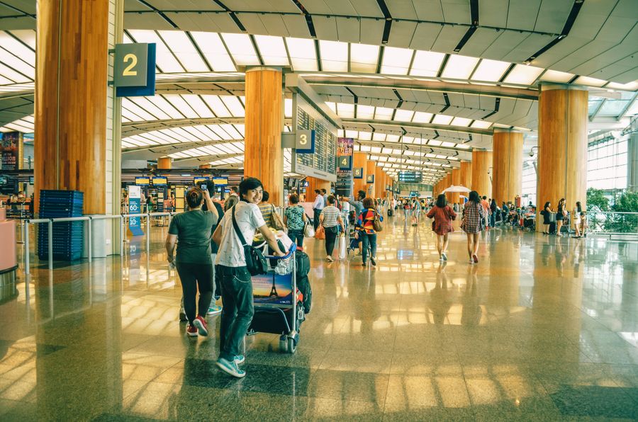 Travellers with luggage inside Singapore Changi Airport terminal