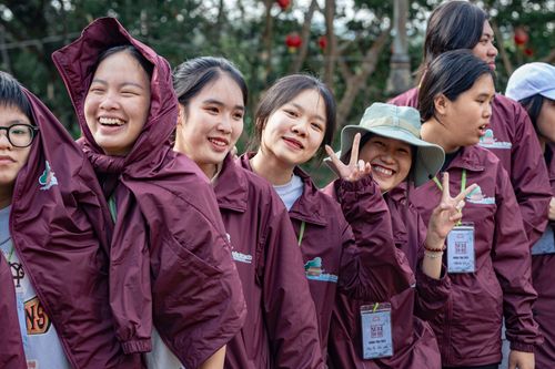 Free A group of young women enjoying a lively outdoor gathering in matching jackets. Stock Photo