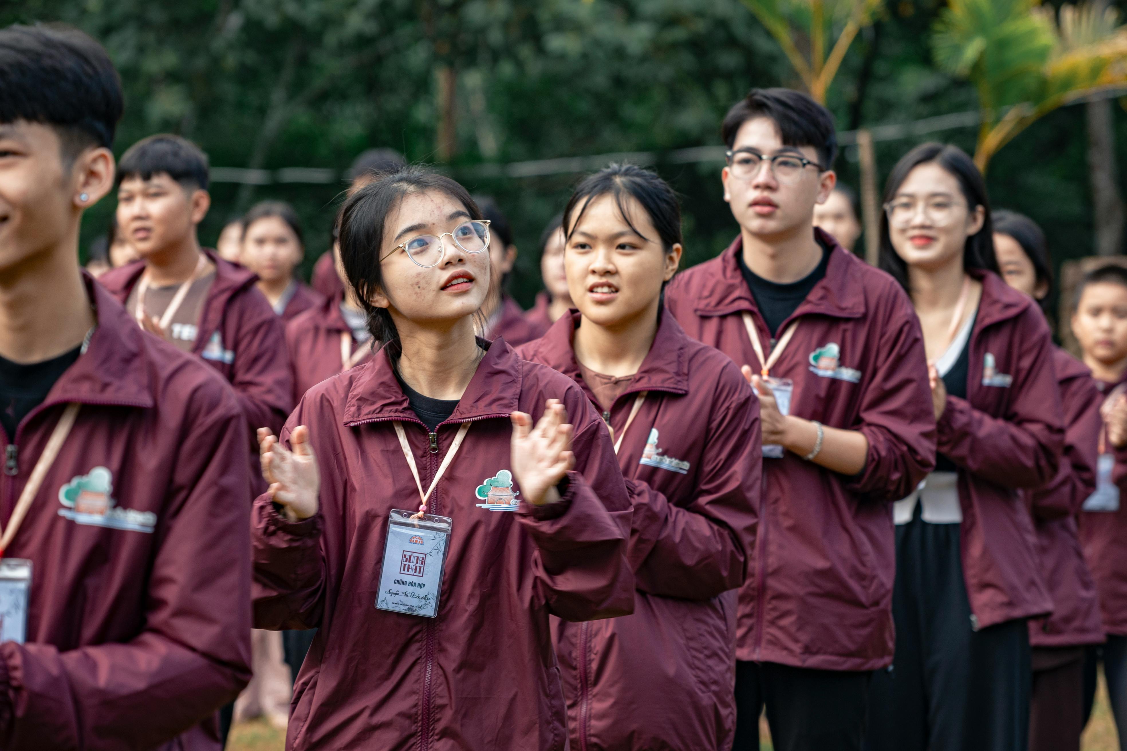 a group of people in maroon jackets standing in a line