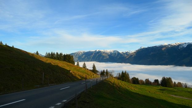 Breathtaking view of a road leading through the Swiss Alps above a sea of clouds in Sarnen.