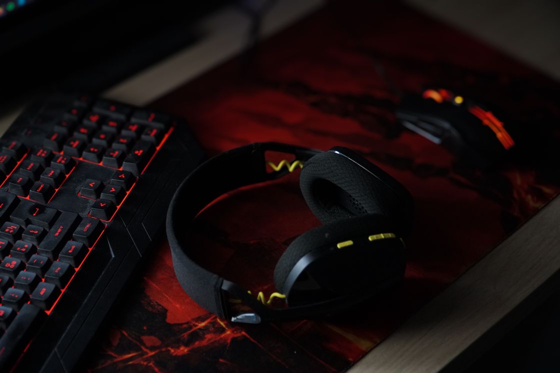 Gaming headset resting beside a backlit keyboard and gaming mouse