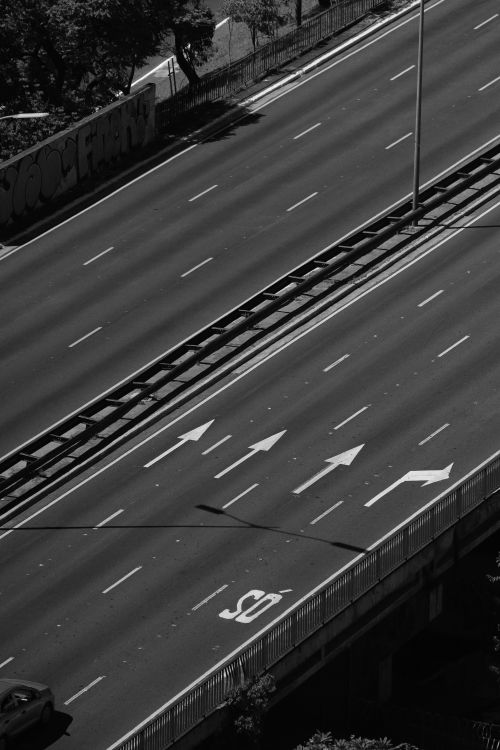 Free Black and white aerial view of an empty urban highway with directional arrows. Stock Photo