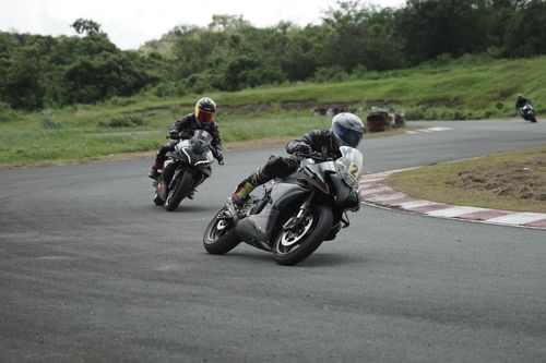 Free Two motorcycle racers speed through a curve on a scenic outdoor track. Stock Photo