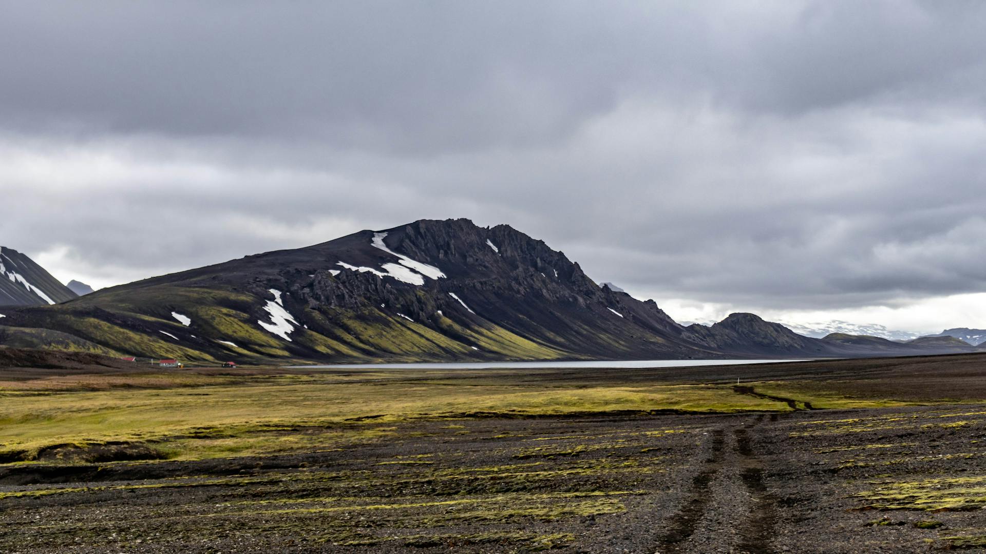 Un paysage islandais spectaculaire avec des montagnes et une toundra sous un ciel nuageux.