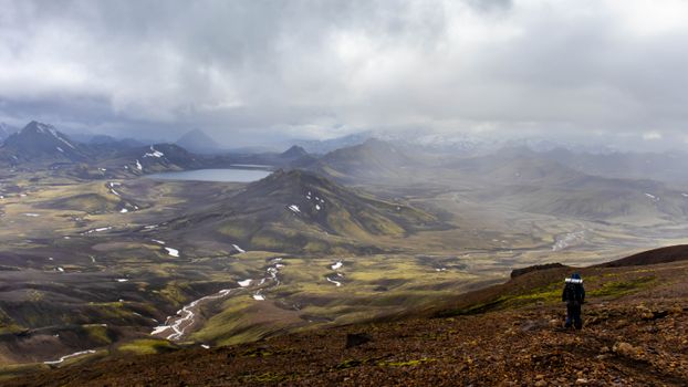 Dramatic view of Landmannalaugar landscape with hiker on Laugavegur trail, Iceland.