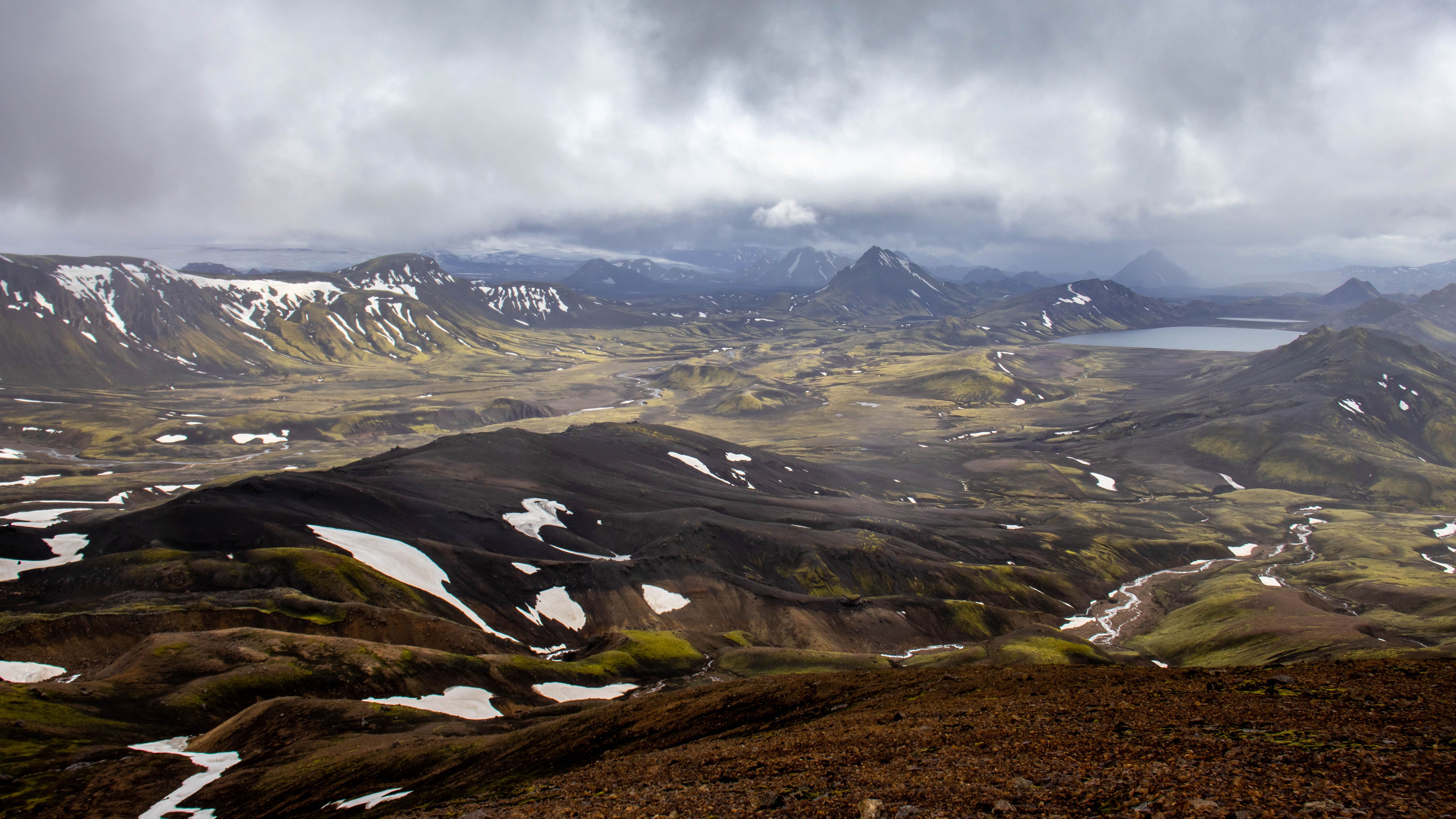 Breathtaking landscape of Landmannalaugar with mountains, snow patches, and dramatic sky. Breathtaking landscape of Landmannalaugar with mountains, snow patches, and dramatic sky.