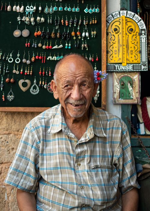 Free Smiling elderly man with jewelry display in Tunis shop, Tunisia. Stock Photo