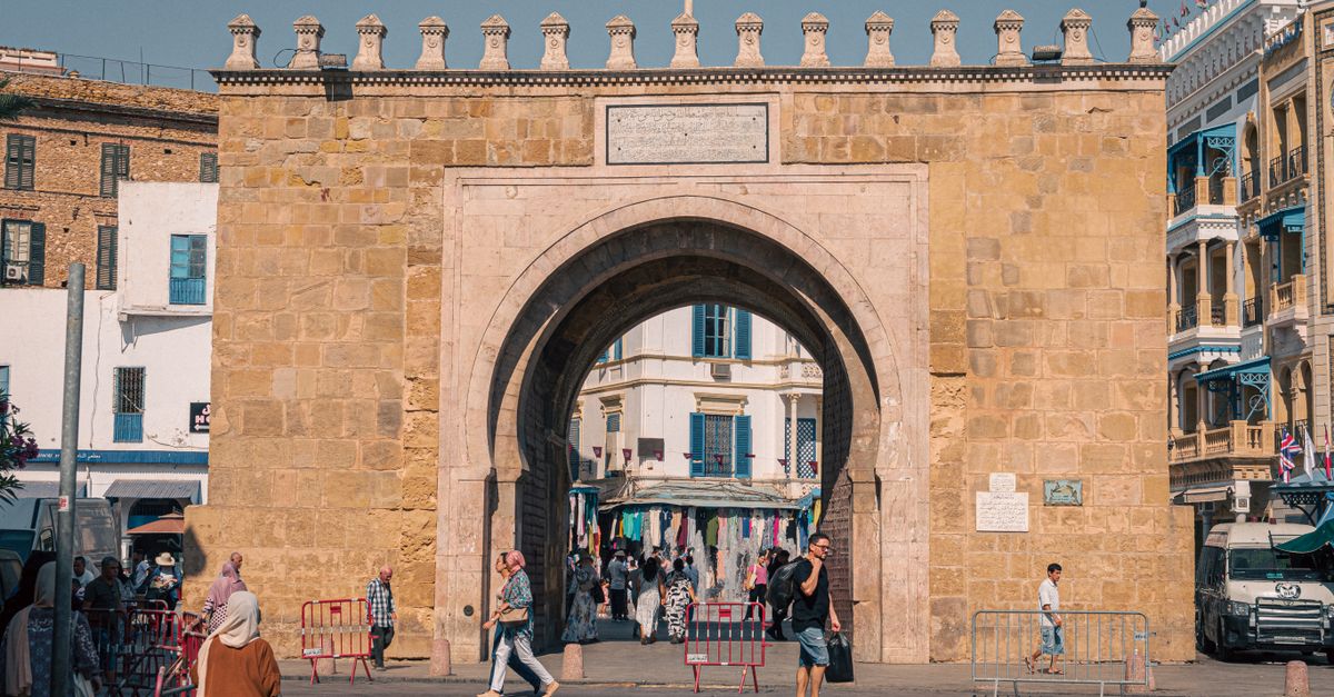 Explore the iconic Bab El Bhar city gate in Tunis, showcasing historical architecture and vibrant street life.
