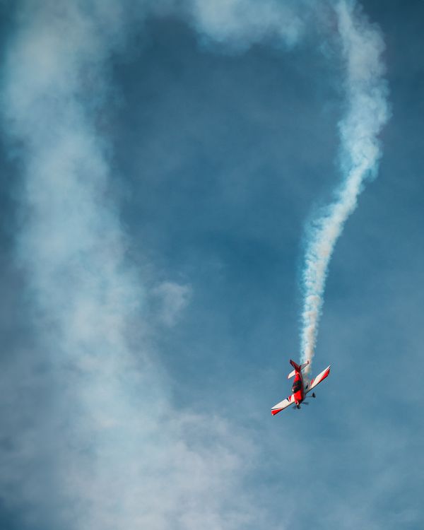 Smoke Flying A small plane flying through the air with smoke coming out of it · Free ...