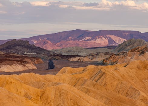Captivating panoramic view of Death Valley's rugged terrain at sunset, showcasing vibrant geological formations.