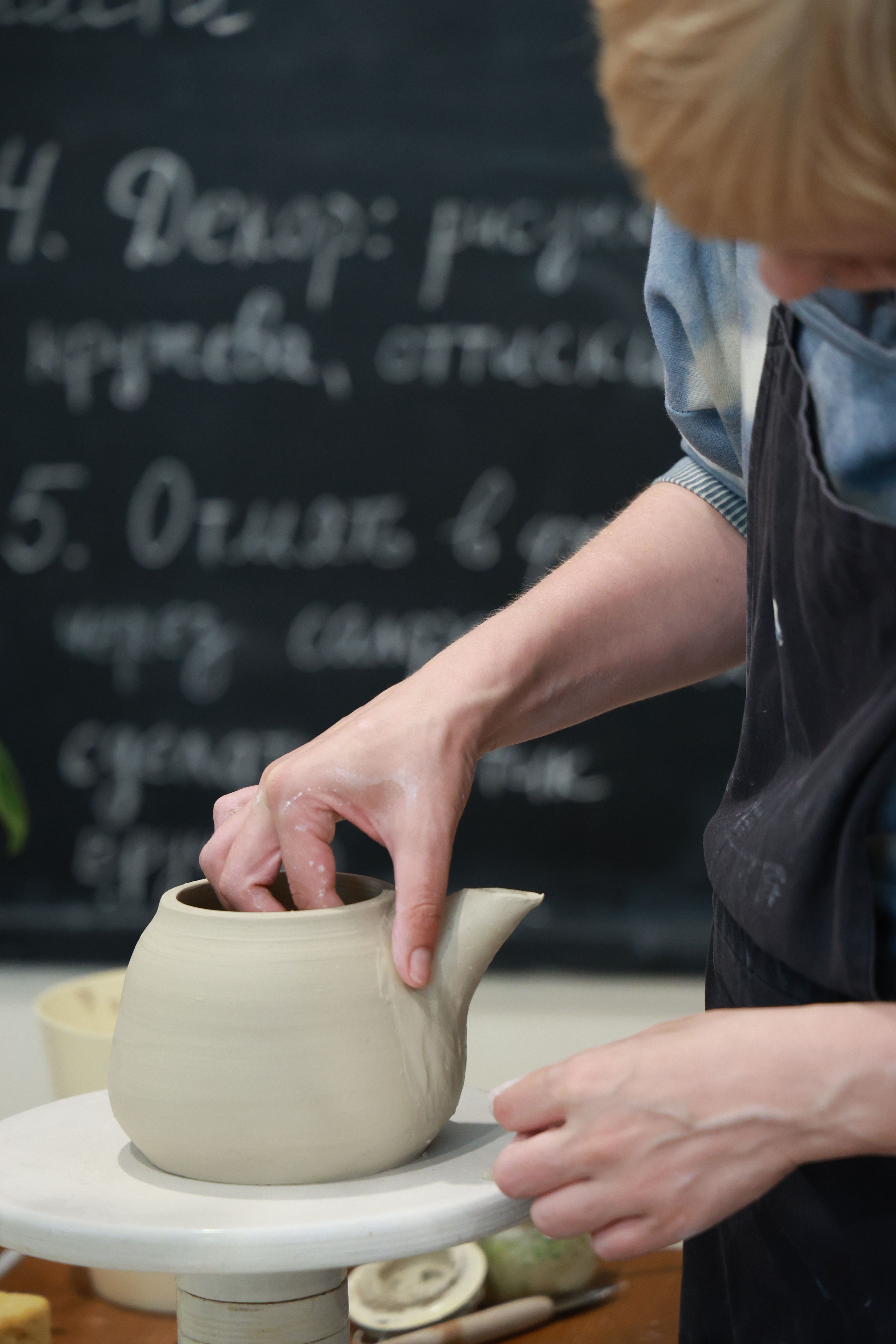 A woman is making a pottery teapot · Free Stock Photo